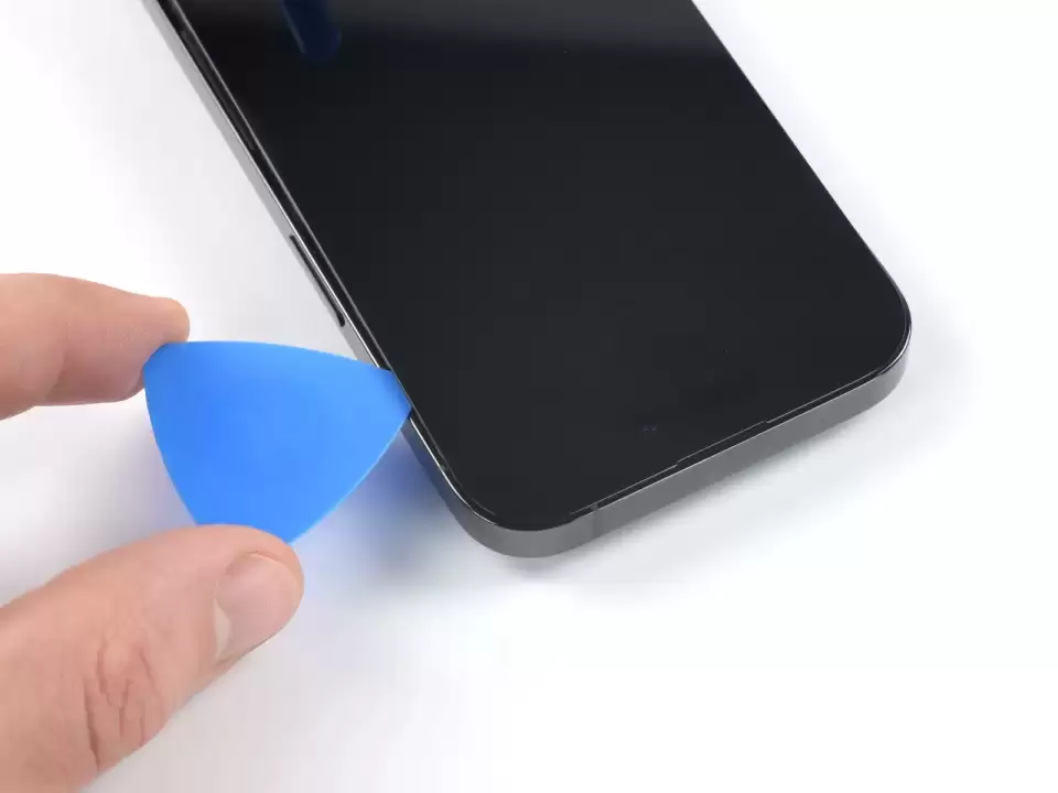 Bước 13 — Trượt miếng nạy dọc mép trên để tách keo